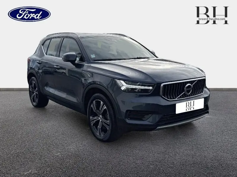 Vue 3/4 avant d'un Volvo XC40 bleu Denim avec calandre verticale chromée et jantes alliage noires.