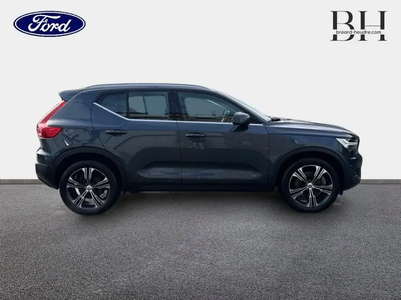 Profil côté gauche d'un Volvo XC40 T4 Recharge bleu Denim avec jantes alliage et lignes épurées.
