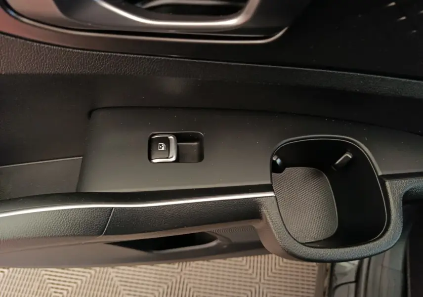 Détail de la commande de verrouillage de porte et porte-gobelet côté conducteur intérieur noir du Kia Sorento 2023 hybride rechargeable.
