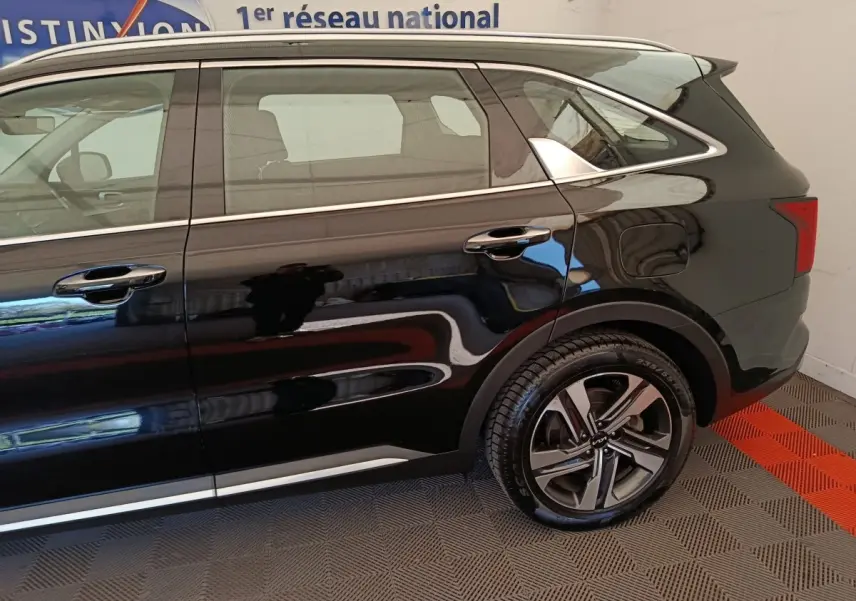 Vue latérale côté droit du Kia Sorento noir 2023, mettant en valeur la jante alliage et les lignes chromées sur les portes.
