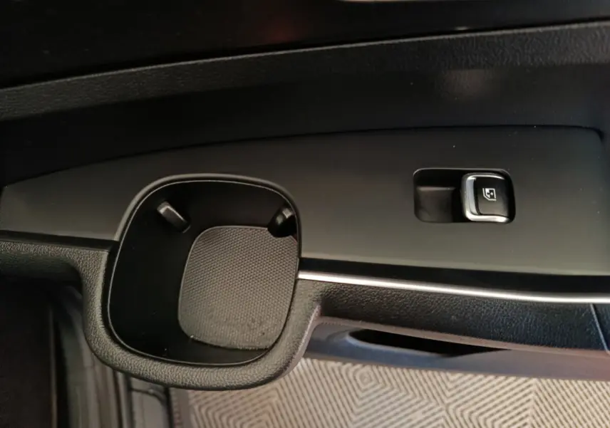 Gros plan sur la commande de lève-vitre et porte-gobelet côté conducteur du KIA Sorento noir 2023.