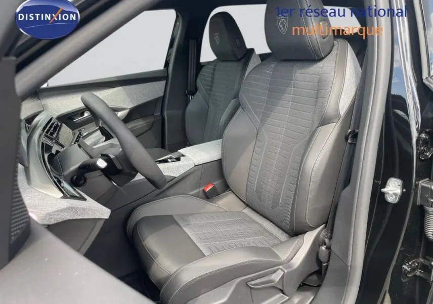 Vue intérieure côté conducteur du Peugeot 5008 noir 2025, mettant en valeur les sièges en cuir et tissu avec logo Peugeot brodé.