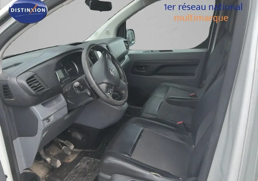 Vue intérieure côté conducteur du Citroën Jumpy blanc 2017, sièges en cuir noir et tableau de bord simple.