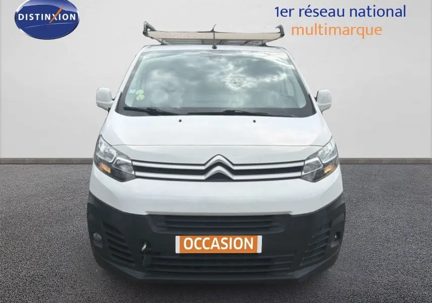 Vue frontale d’un Citroën Jumpy XL blanc de 2017 avec calandre noire et porte-échelle sur le toit.