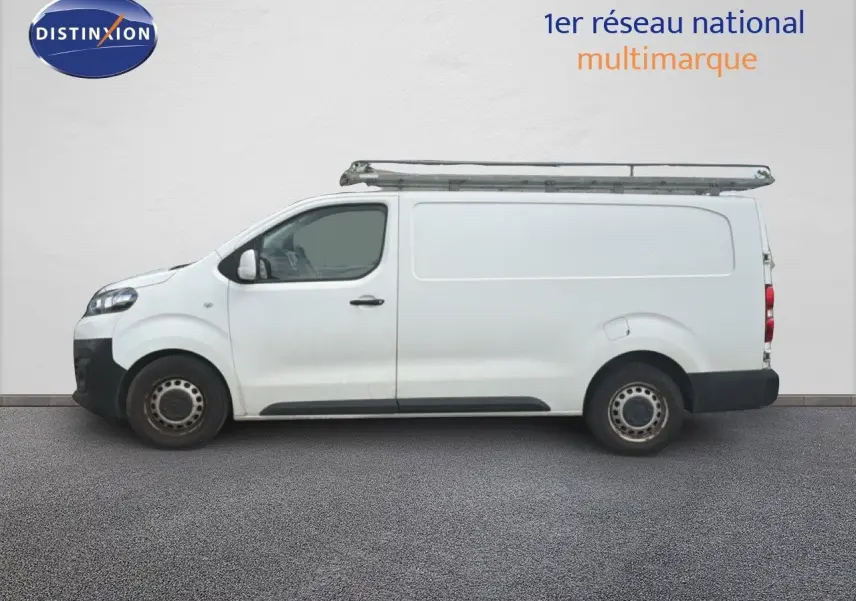 Vue de profil côté gauche d’un utilitaire Citroën Jumpy XL blanc avec galerie de toit métallique.