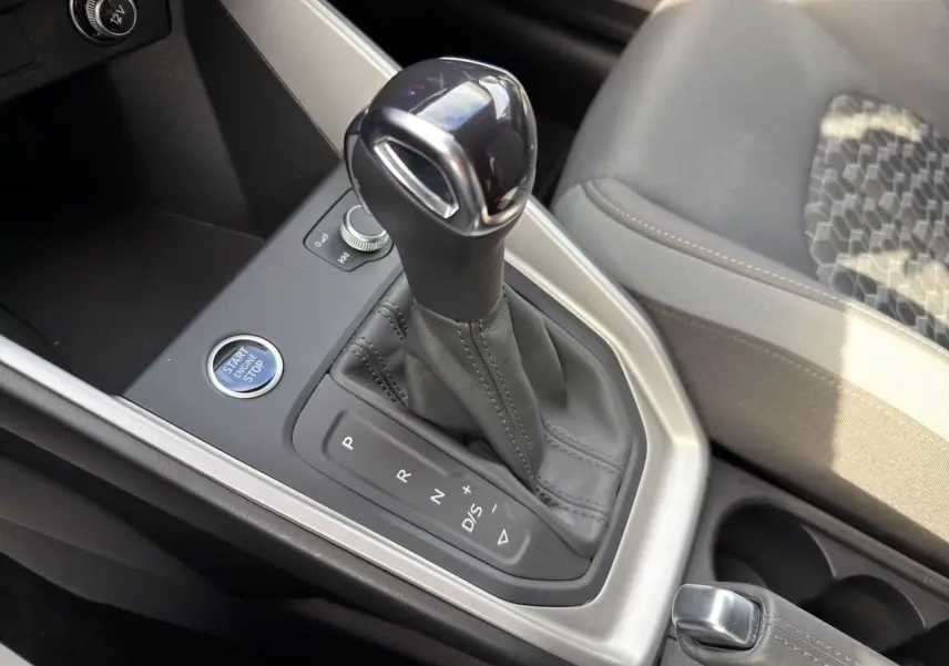 Gros plan sur la console centrale de l’Audi A1 Sportback 2025, montrant le levier de vitesses automatique noir et cuir.