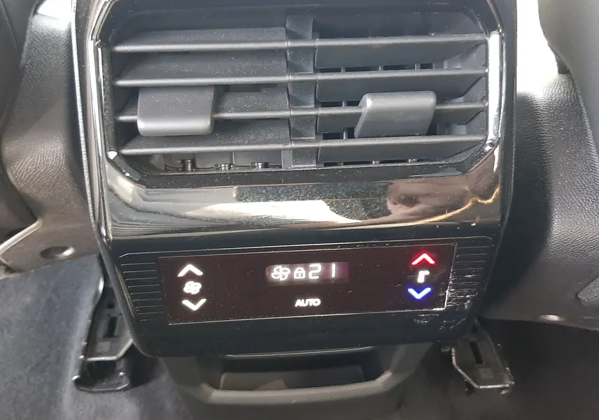 Vue rapprochée de la commande de climatisation arrière noire du Peugeot 5008 gris Artense, affichant 21°C en mode auto.