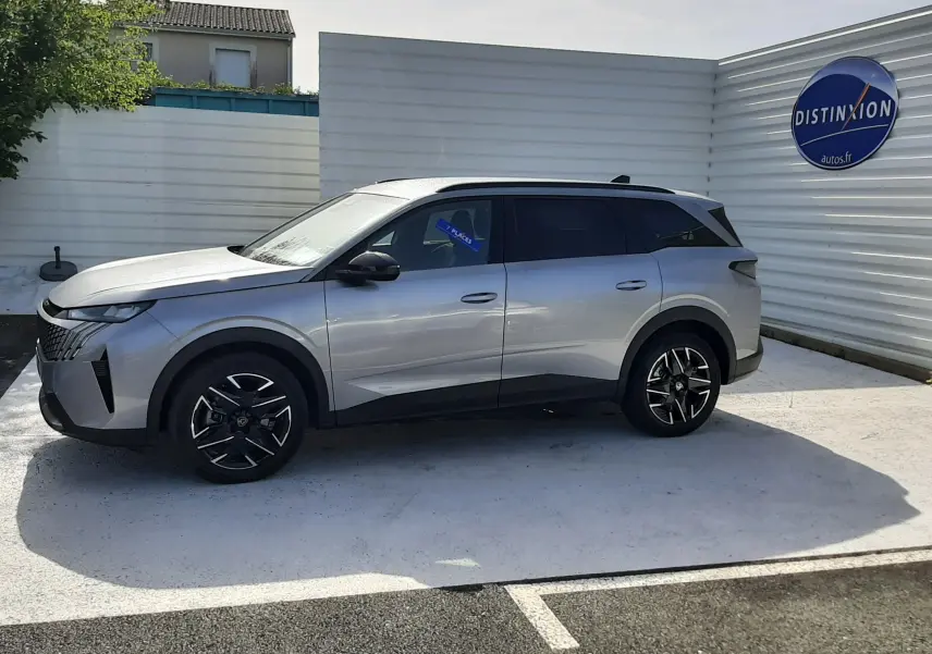 Peugeot 5008 Hybrid gris Artense métal vu de profil côté gauche, avec jantes noires et toit panoramique.