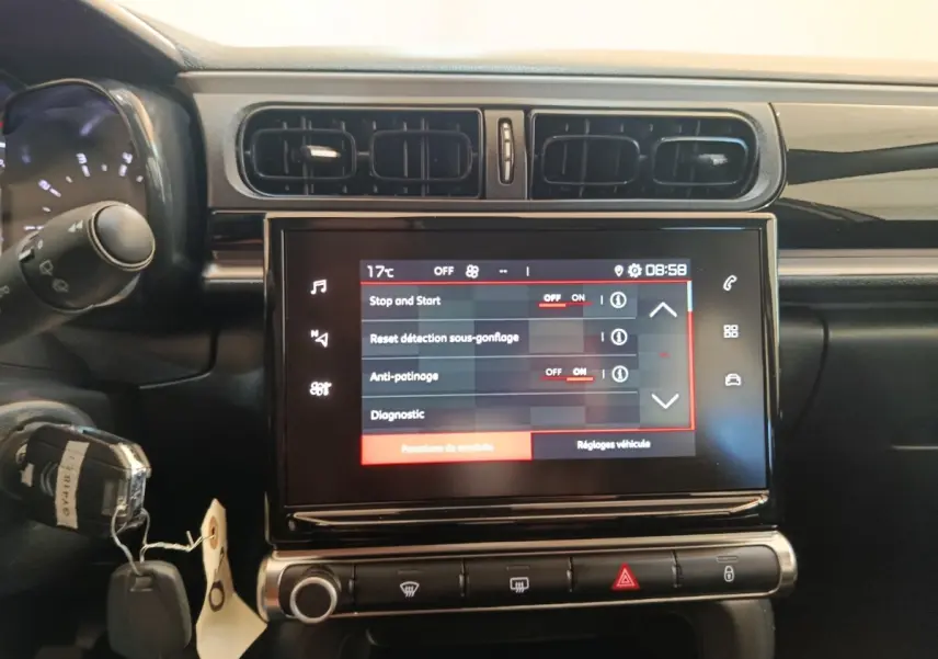 Vue rapprochée de l’écran tactile central et des commandes du tableau de bord d’une Citroën C3 gris foncé 2024.