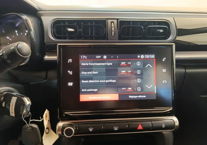 Écran tactile central allumé du tableau de bord d'une Citroën C3 gris foncé, vue frontale rapprochée.