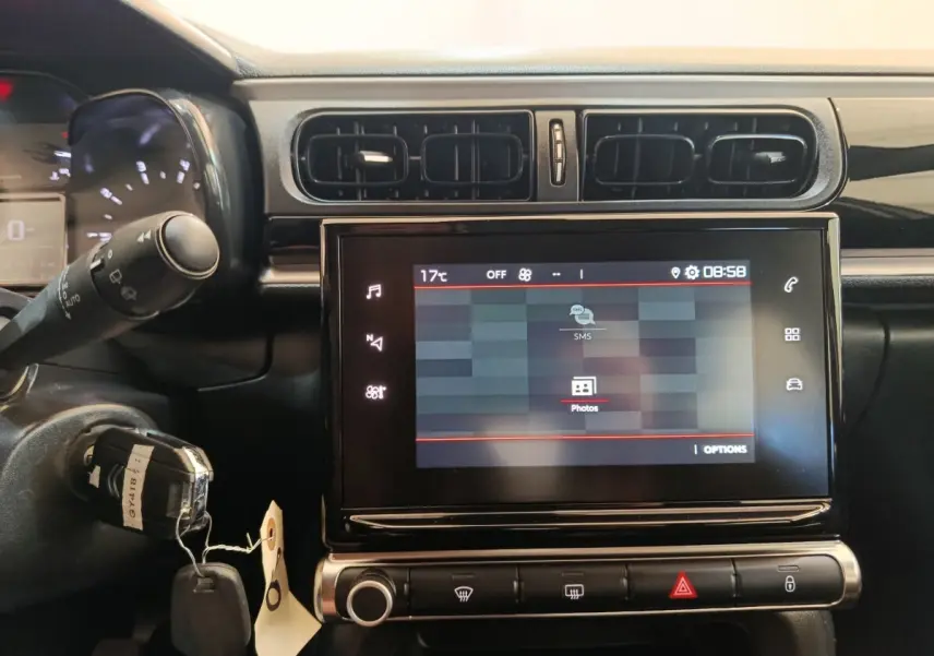 Vue rapprochée du tableau de bord central tactile de la Citroën C3 2024, avec commandes et écran allumé.