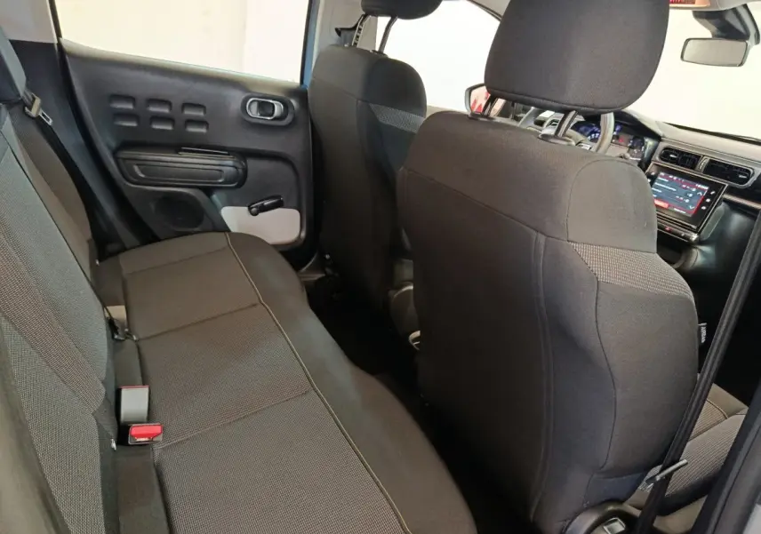Vue intérieure arrière droite de la Citroën C3 2024 gris foncé, montrant la banquette et le tableau de bord tactile avant.