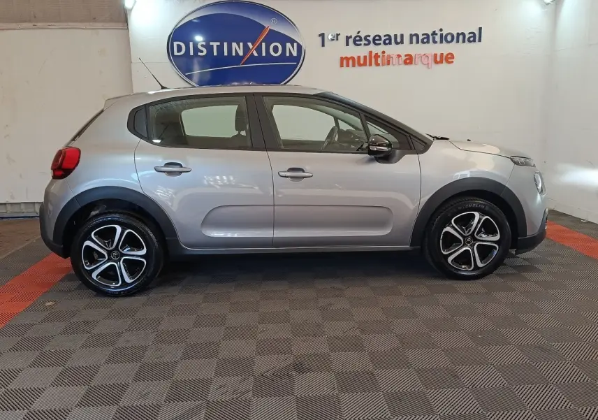 Profil droit d'une Citroën C3 gris foncé 2024, avec jantes alliage et protections noires sur les passages de roues.
