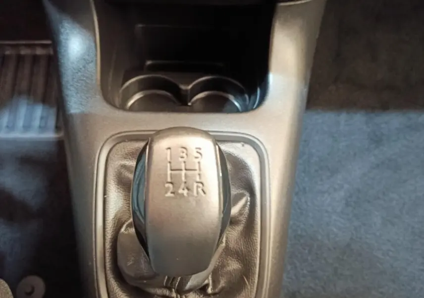 Gros plan sur le levier de vitesse manuel noir de la Citroën C3 PureTech 83 BVM PLUS 2024, intérieur gris foncé.