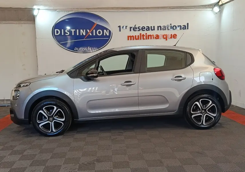 Vue de profil côté gauche d'une Citroën C3 gris foncé 2024 avec jantes alliage et poignées ton caisse.