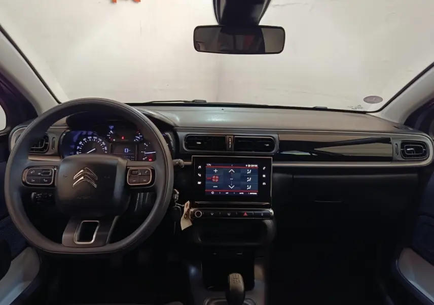 Vue intérieure frontale du tableau de bord de la Citroën C3 gris foncé 2024 avec écran tactile central et volant multifonctions.