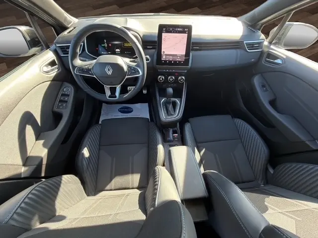 Vue intérieure avant de la Renault Clio Esprit Alpine E-Tech 2025, tableau de bord avec écran tactile vertical et volant multifonctions.