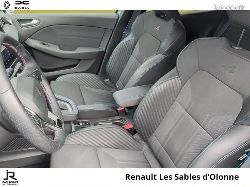 Vue intérieure côté conducteur de la Renault Clio Esprit Alpine gris clair, sièges sport avec logo Alpine brodé.