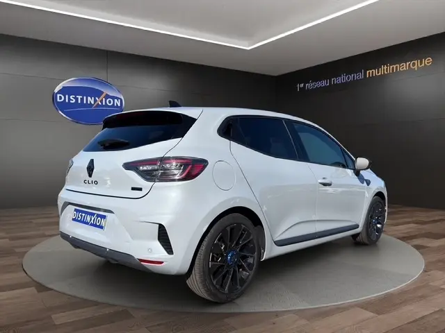 Vue 3/4 arrière droite d'une Renault Clio Esprit Alpine E-Tech gris clair avec jantes noires et toit noir en showroom.