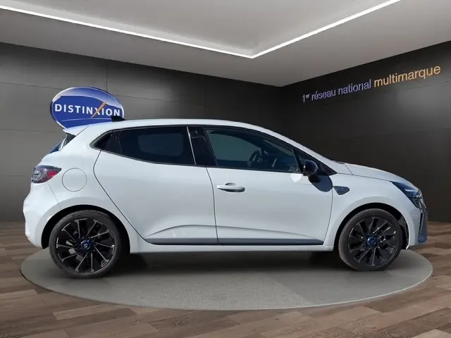 Profil droit d'une Renault Clio Esprit Alpine E-Tech 2025 gris clair avec jantes noires et vitres teintées.
