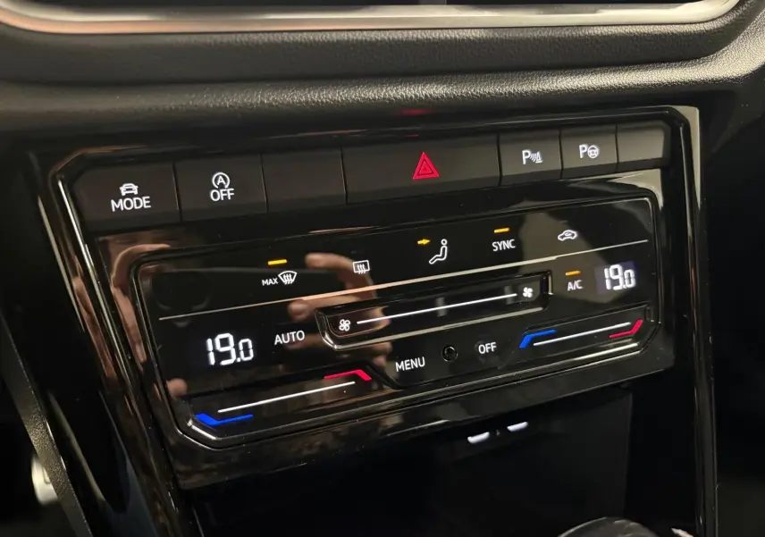 Panneau de commande de la climatisation du Volkswagen T-Roc 2024 avec affichage digital et boutons tactiles noirs.