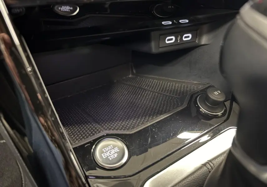 Gros plan sur la console centrale du Volkswagen T-Roc 2024, bouton Start Engine Stop et prises USB visibles.