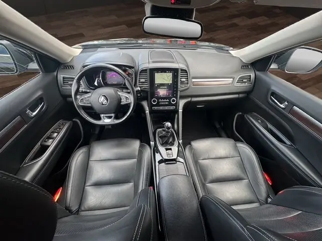 Vue intérieure avant du Renault Koleos 2017 noir avec cuir, volant multifonction, écran tactile et boîte manuelle.