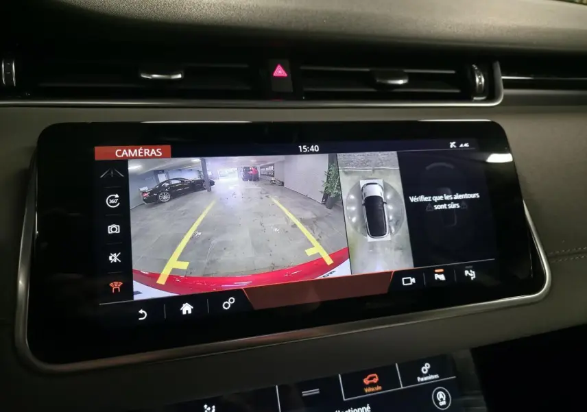 Écran tactile intérieur montrant la caméra de recul et vue 360° d’un Range Rover Evoque rouge en parking.