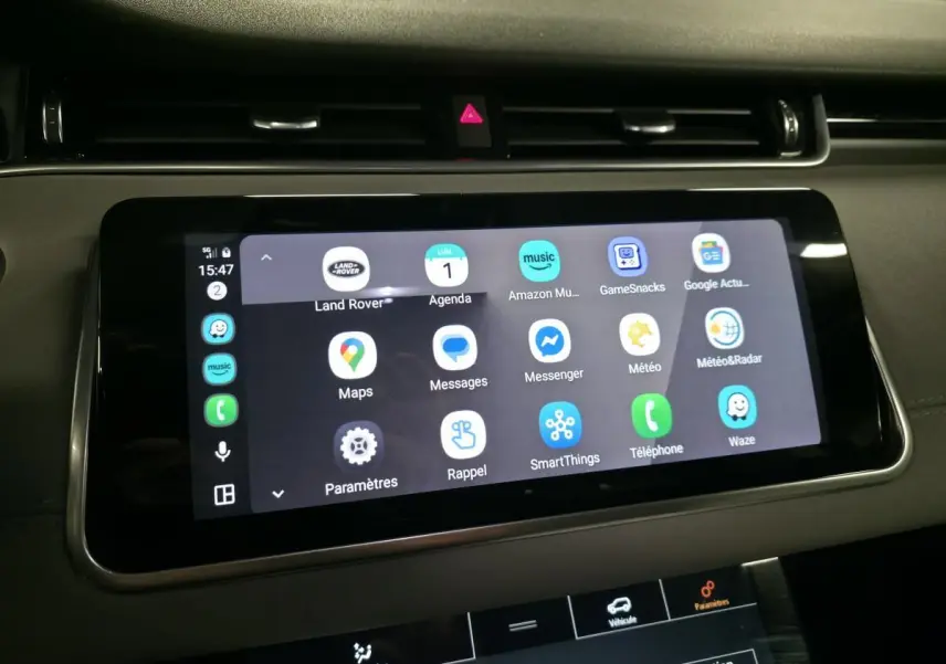 Écran tactile central du Range Rover Evoque 2019 affichant plusieurs applications connectées, intérieur sombre.