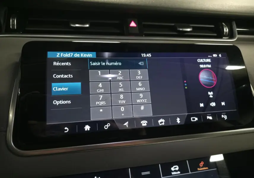 Écran tactile central du Range Rover Evoque rouge 2019 affichant le clavier téléphonique et la radio FM