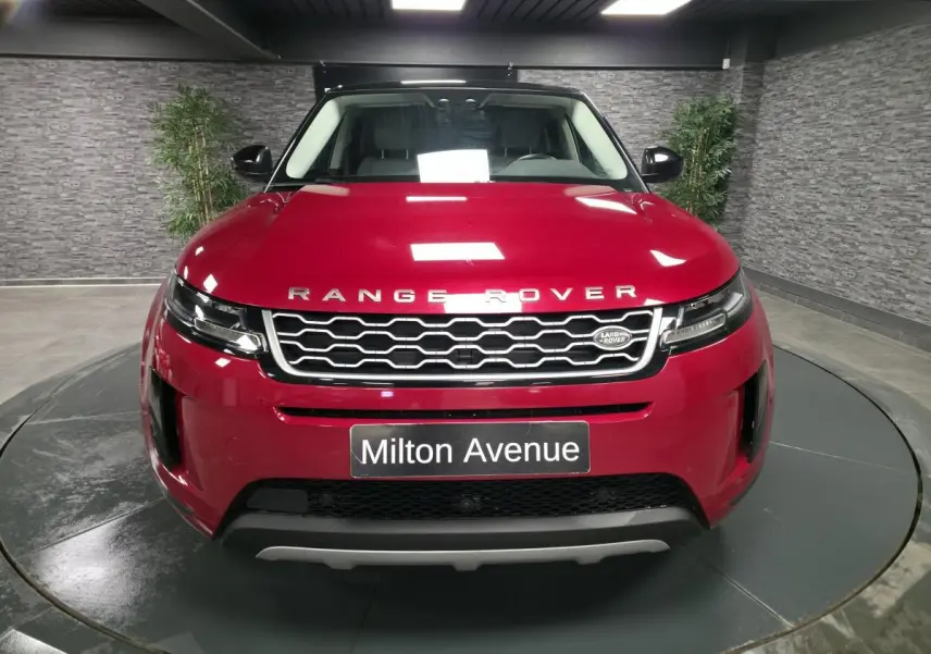 Vue frontale d'un Range Rover Evoque rouge métallisé avec calandre hexagonale et logo Land Rover visible.