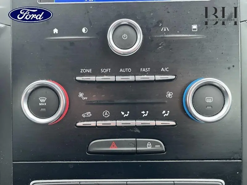 Panneau de commande de climatisation avec boutons et molettes rouge et bleu sur fond noir, intérieur Renault Mégane Break gris platine.