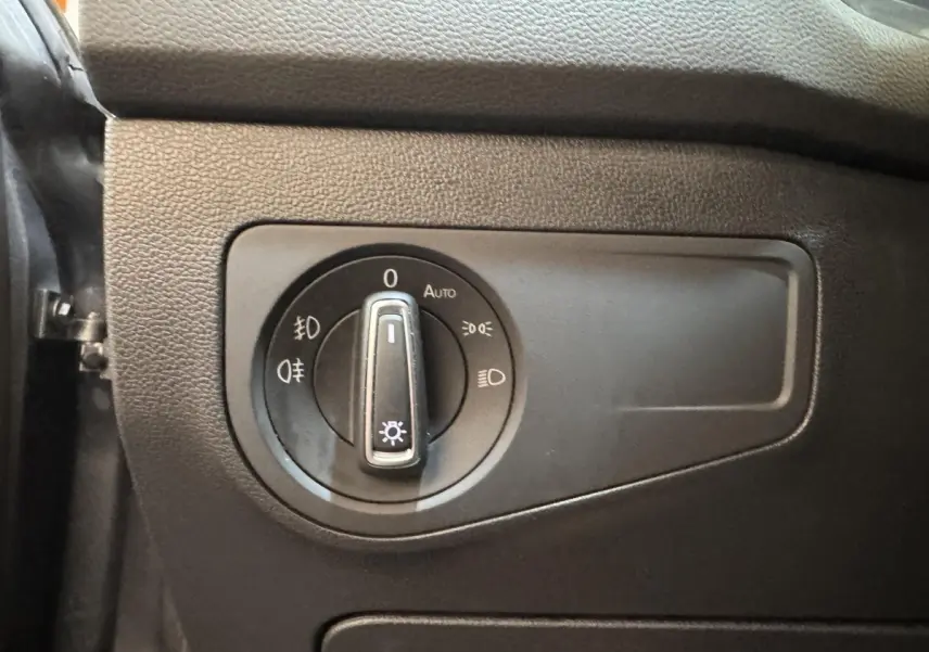 Gros plan sur le bouton de commande des phares du Volkswagen Tiguan Allspace gris foncé, intérieur côté gauche.