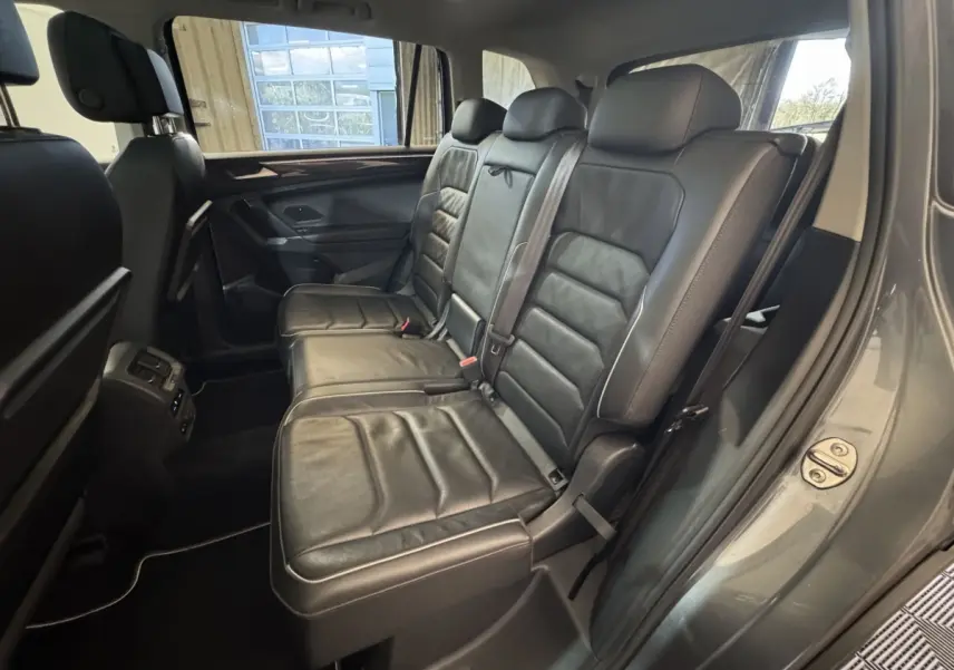 Vue intérieure côté droit sur la banquette arrière en cuir noir du Volkswagen Tiguan Allspace gris foncé 2019.
