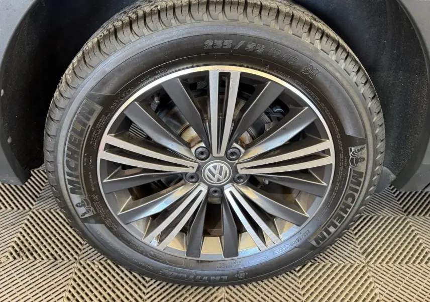 Gros plan sur la jante alliage grise et pneu Michelin d'un Volkswagen Tiguan Allspace gris foncé, roue avant droite.