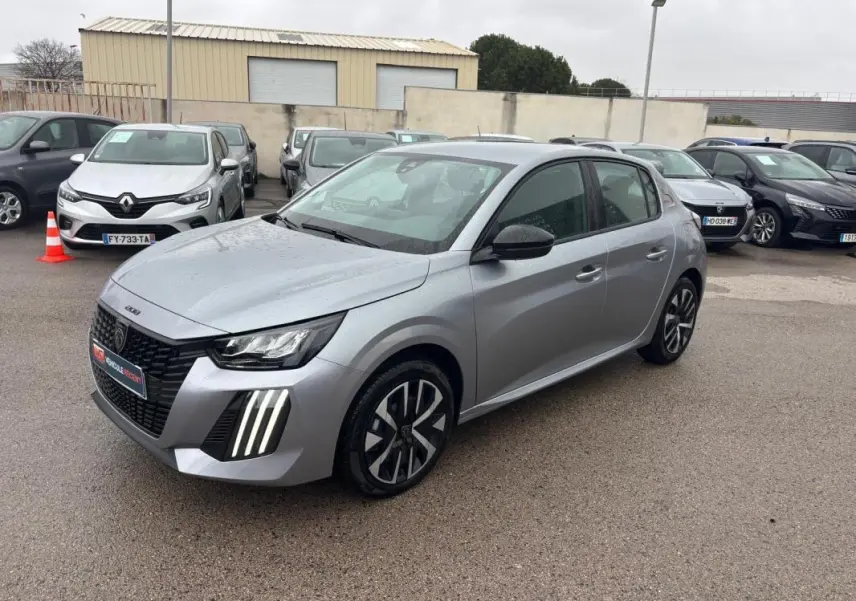 Peugeot 208 gris en 3/4 avant droit, avec feux diurnes à LED verticaux et jantes alliage 16 pouces.