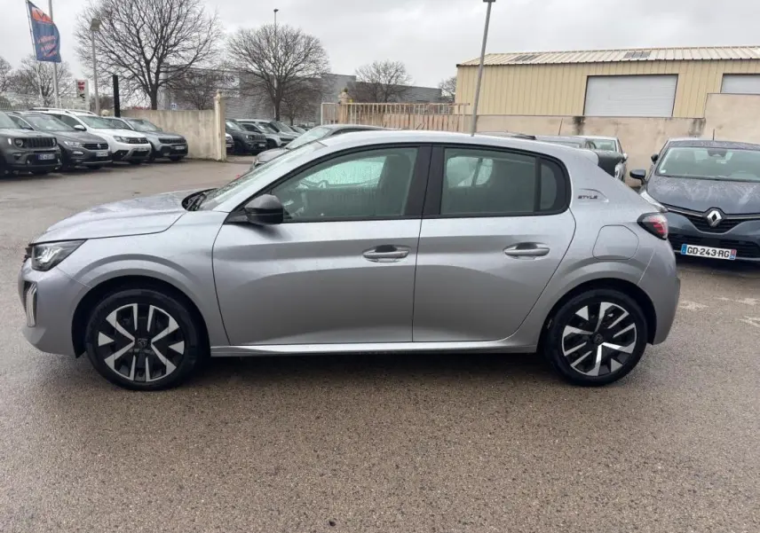 Peugeot 208 Hybrid gris vue de profil côté gauche, avec jantes 16 pouces et badge Style sur l'aile arrière.