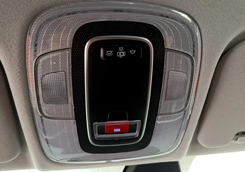 Vue en gros plan du plafonnier intérieur gris clair de la Hyundai i20 2022 avec bouton d'appel d'urgence SOS rouge.