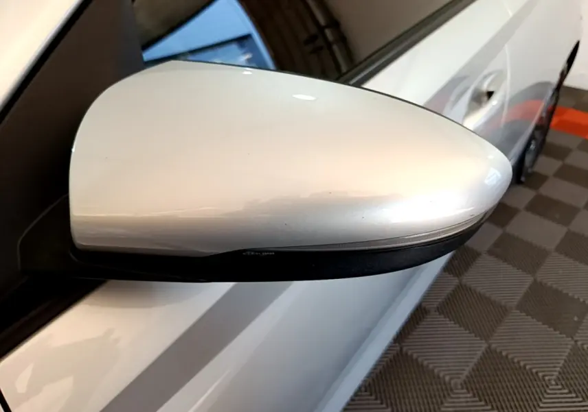 Rétroviseur droit gris clair de la Hyundai i20 2022, vue rapprochée sur la portière et poignée côté droit.