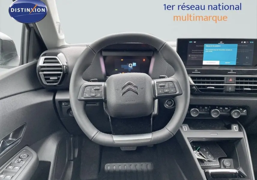 Vue intérieure centrée sur le volant cuir et le tableau de bord numérique de la Citroën C4 2024, finition moderne.