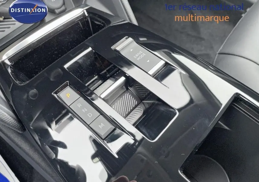 Gros plan sur la console centrale noire brillante de la Citroën C4 blanche, avec commande de boîte auto et bouton Drive Mode.