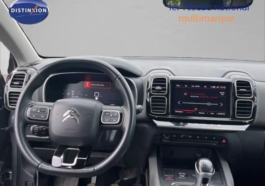 Vue intérieure du poste de conduite du Citroën C5 Aircross gris clair, avec tableau de bord numérique et écran tactile central.