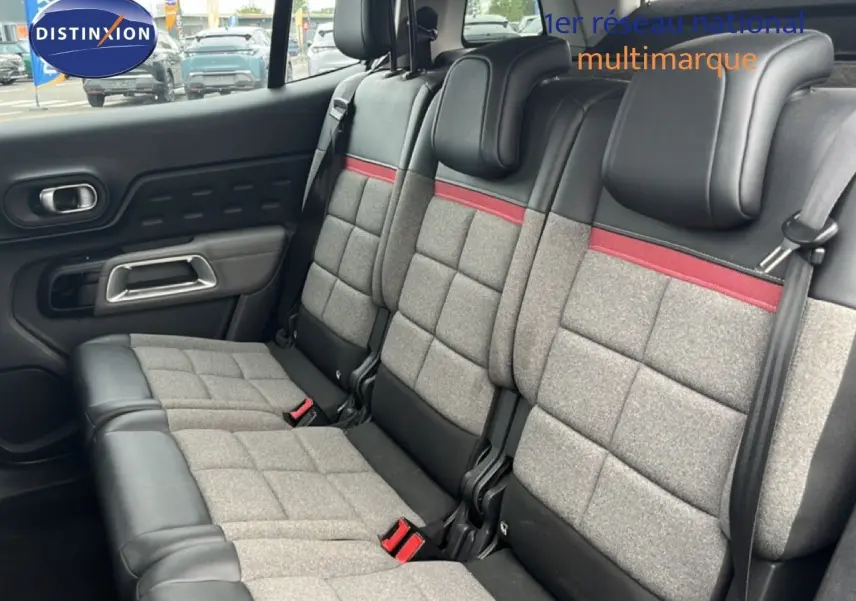 Vue intérieure sur la banquette arrière du Citroën C5 Aircross gris clair, avec sellerie tissu gris et détails rouges.