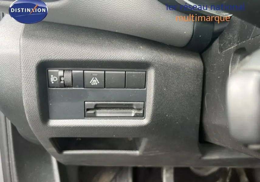 Détail intérieur montrant les commandes de réglage des phares et d'aide à la conduite sur le tableau de bord noir du Citroën C5 Aircross.