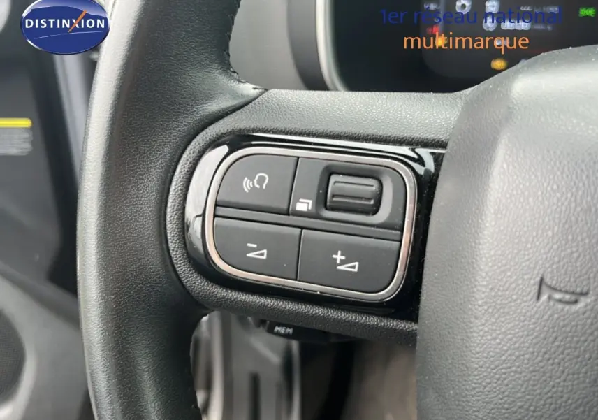 Gros plan sur les commandes au volant gauche du Citroën C5 Aircross gris clair métal, version PureTech 130ch Feel 2020.