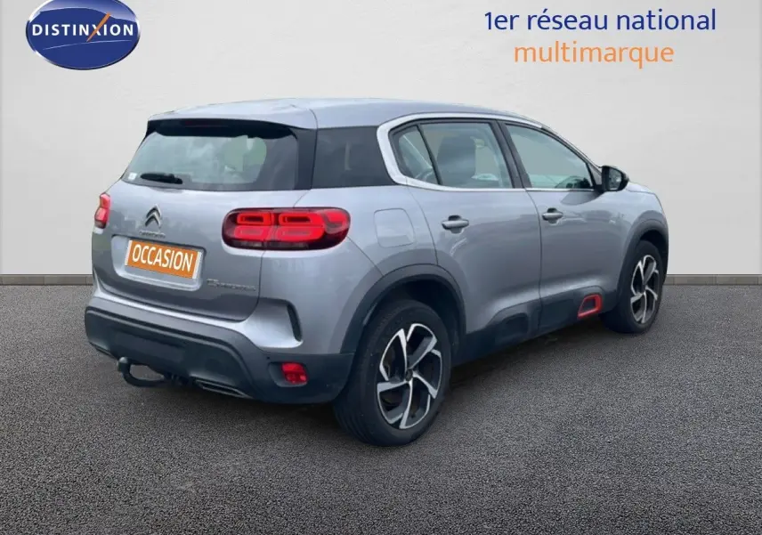 Vue 3/4 arrière droite d'un Citroën C5 Aircross gris clair métal avec feux arrière LED et jantes alliage distinctives.
