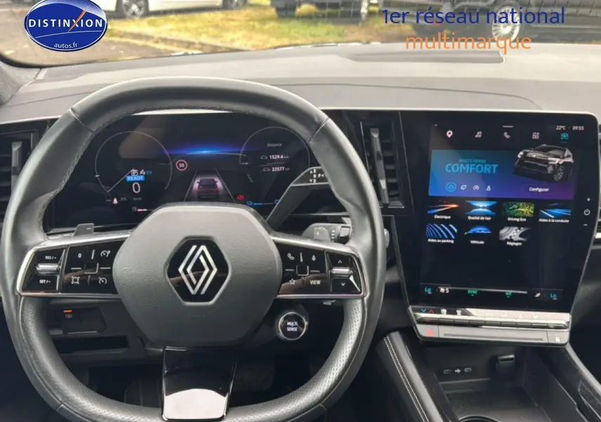 Vue intérieure centrée sur le volant cuir et l’écran tactile du tableau de bord du Renault Austral gris schiste 2024.