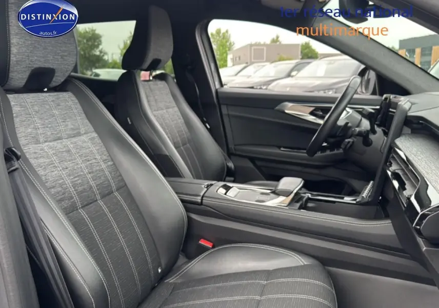 Vue intérieure côté conducteur du Renault Austral 2024, sièges tissu et cuir gris avec console centrale moderne.