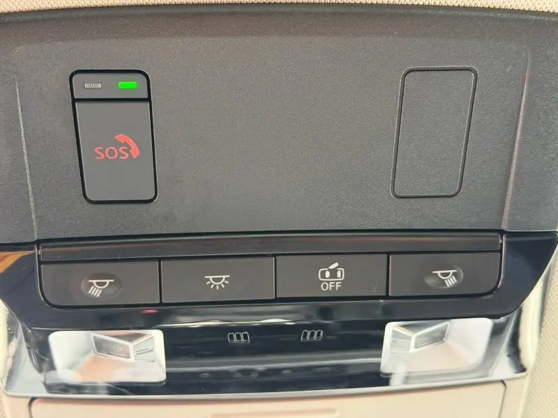 Gros plan sur la console intérieure du Nissan Qashqai 2025, montrant les boutons d'éclairage et d'appel d'urgence SOS.