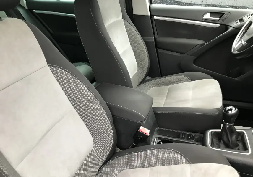 Vue intérieure côté droit du Volkswagen Tiguan Sportline 2012, sièges tissu gris clair et foncé avec levier de vitesse manuel.